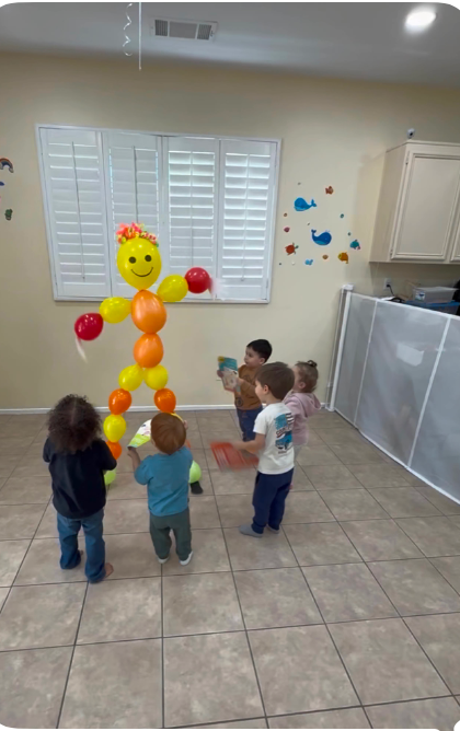 Children playing with balloon figure at Fairy Tale Child Care