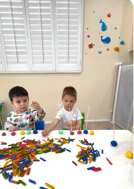Children making crafts with playdoh and pasta at Fairy Tale Child Care